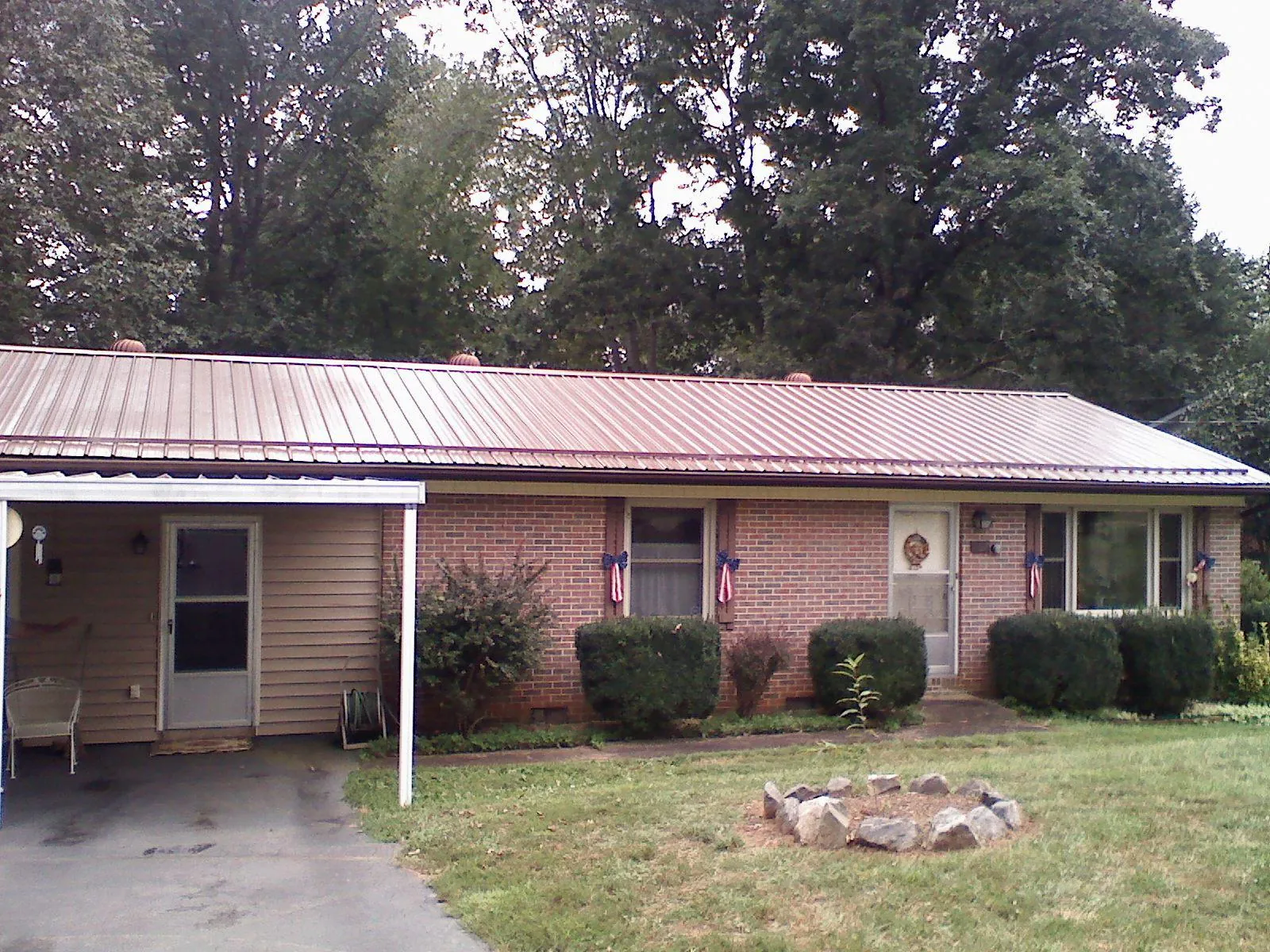 Bronze metal roof and carport on a brick ranch home — Roof Repair work by our crew in Farmington